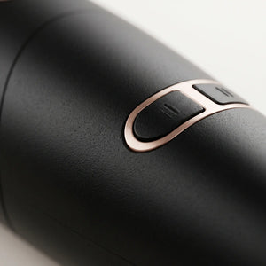 Close-up of a BELARO hair styling tool showing rose gold control buttons and matte black finish