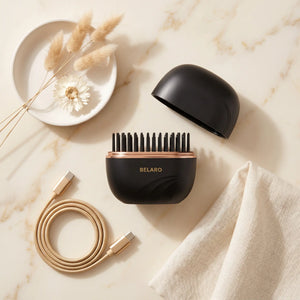 BELARO compact cordless hairbrush with charging cable arranged on a marble surface