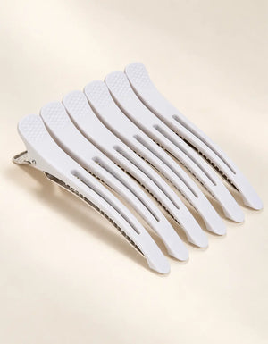 Set of white BELARO professional hair sectioning clips on a cream background