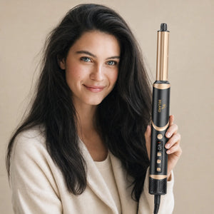 Woman holding the BELARO 8-in-1 hair styler with soft voluminous hair on a cream background