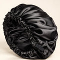 Black BELARO double-layer satin sleep bonnet with elastic edge on a cream background