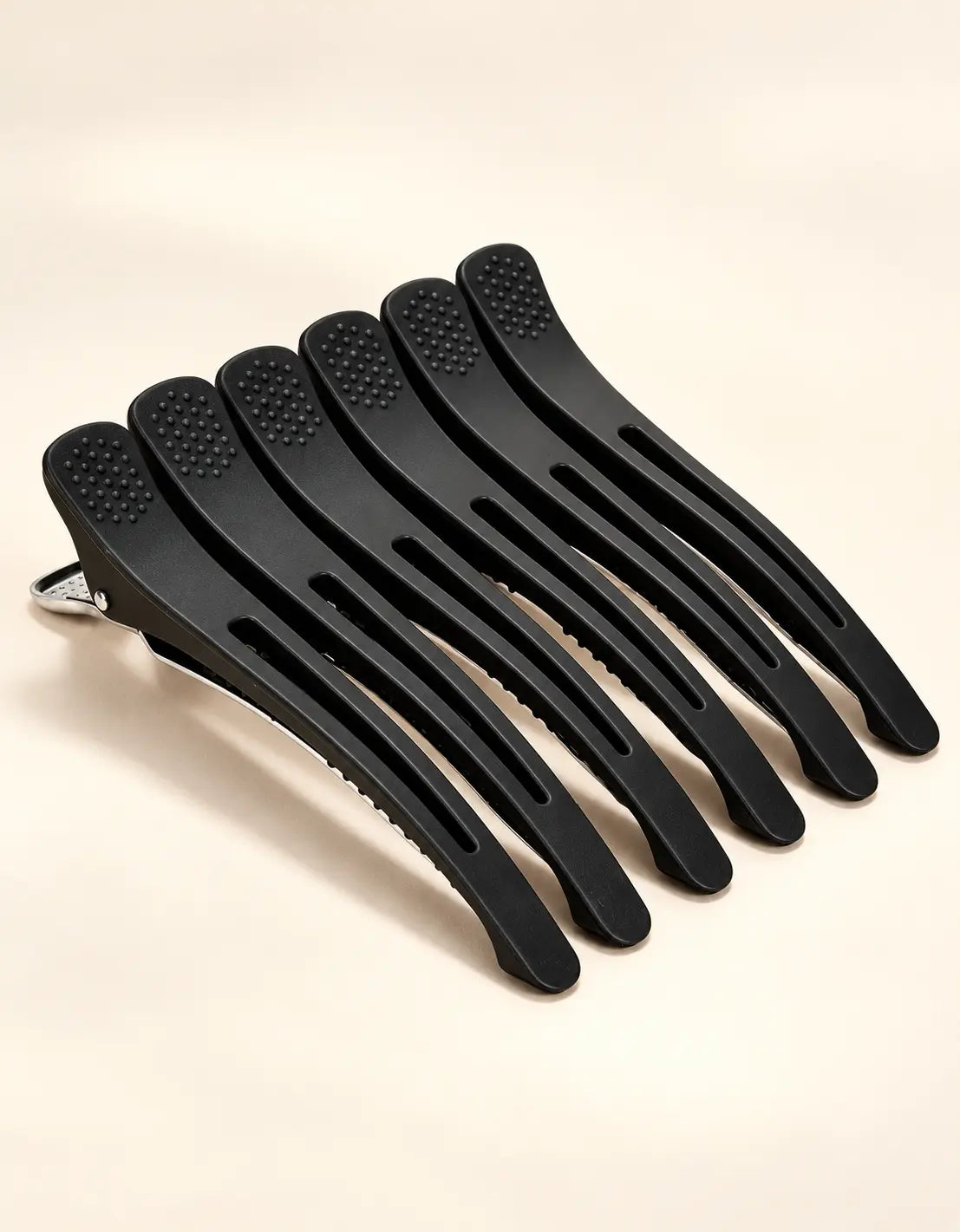 Set of black BELARO professional hair sectioning clips on a cream background
